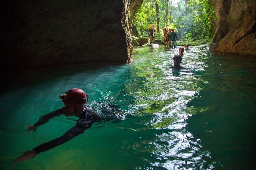 Belize ATM Cave, Belize Cave Exploration Day Tours guests swimming in the belize atm cave
