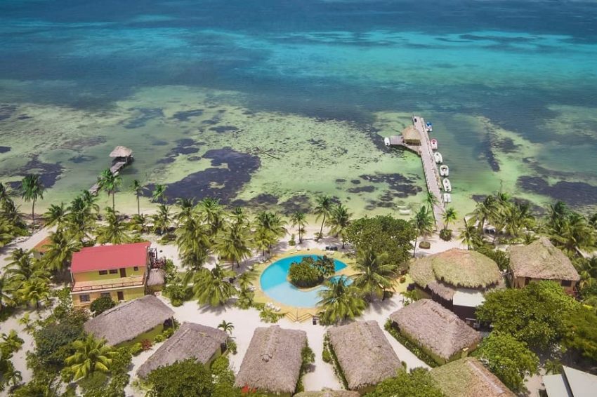 aerial view of the cabanas, pool and dock at portofino beach resort on ambergris caye in belize