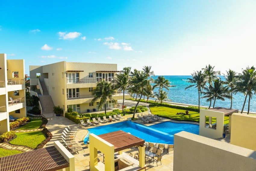 the view from the beach view suite overlooking the main pool at the phoenix resort on the island of ambergris caye in belize