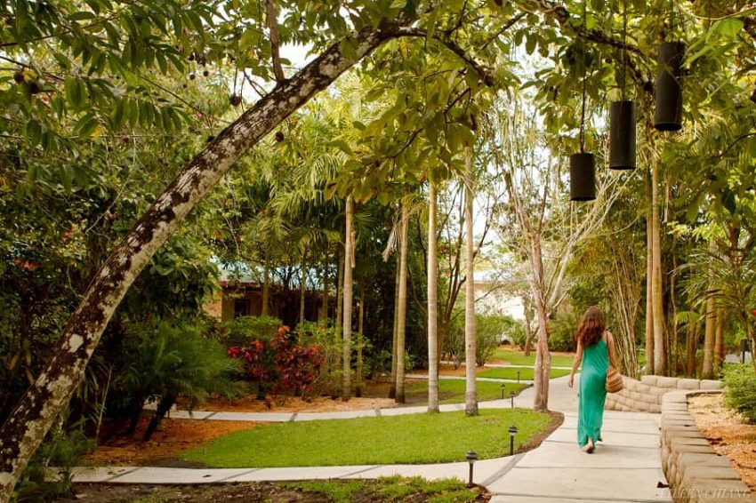 lady in green walking around the property of ka'ana boutique resort in san ignacio belize