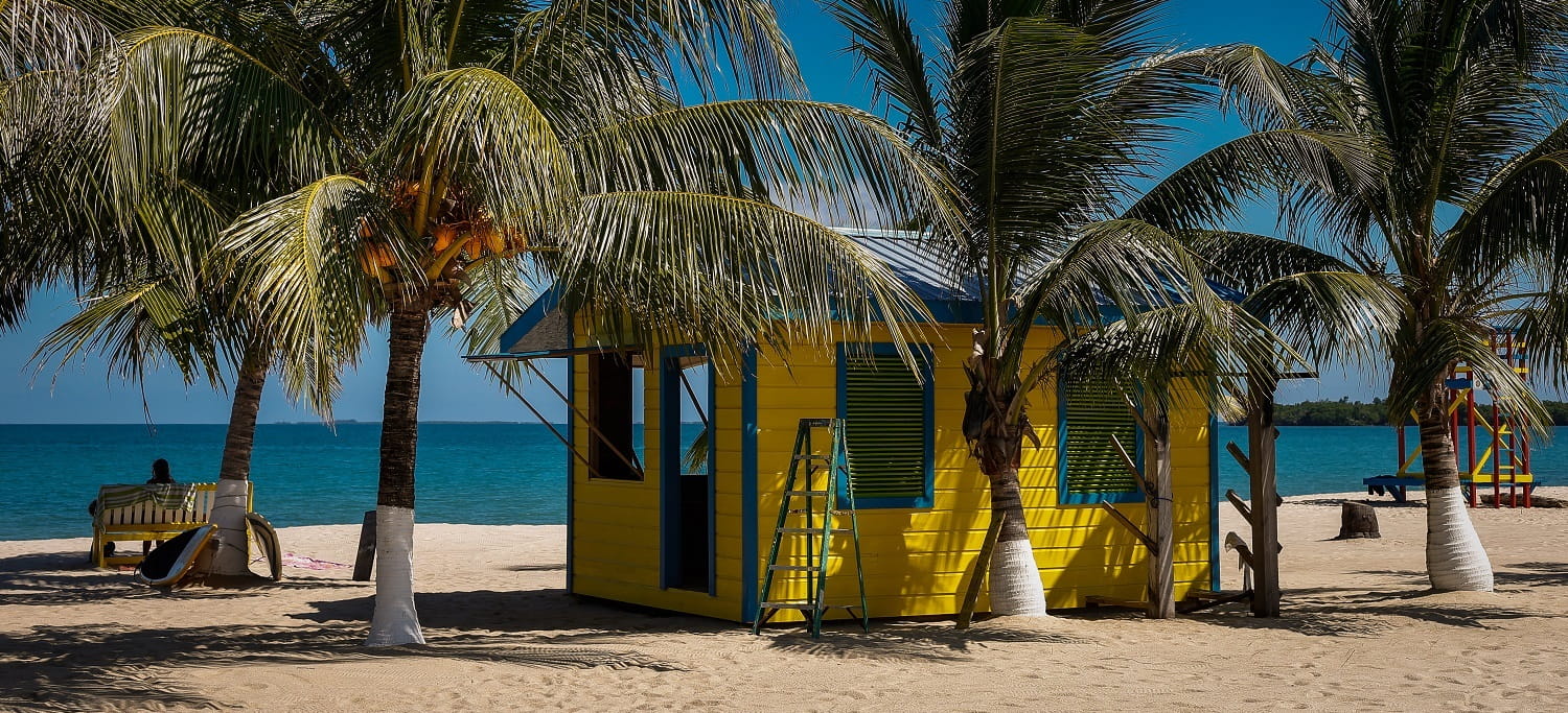 a yellow cabin on the beach of placencia in southern belize