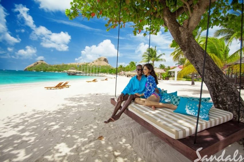 couple relaxing on the beach hammock at sandals grande st lucian in st lucia a sandals all inclusive resorts