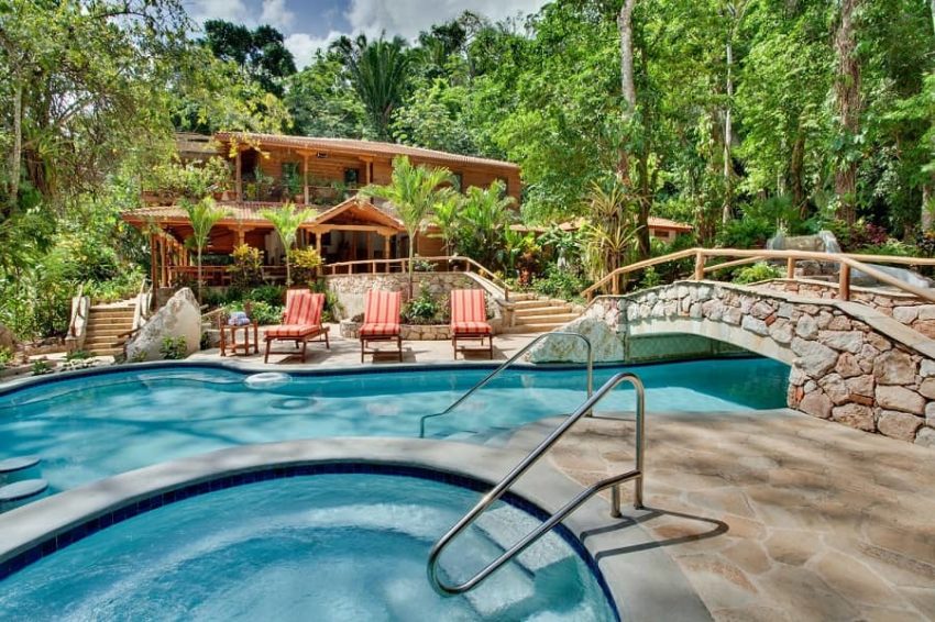 Cave Branch Jungle Lodge, Cayo District the main lodge surrounded by jungle with a view of the pool at cave branch lodge belize