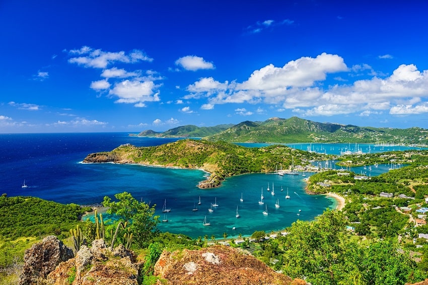 shirley heights with boats in the habour with the mountain in the back drop in antigua