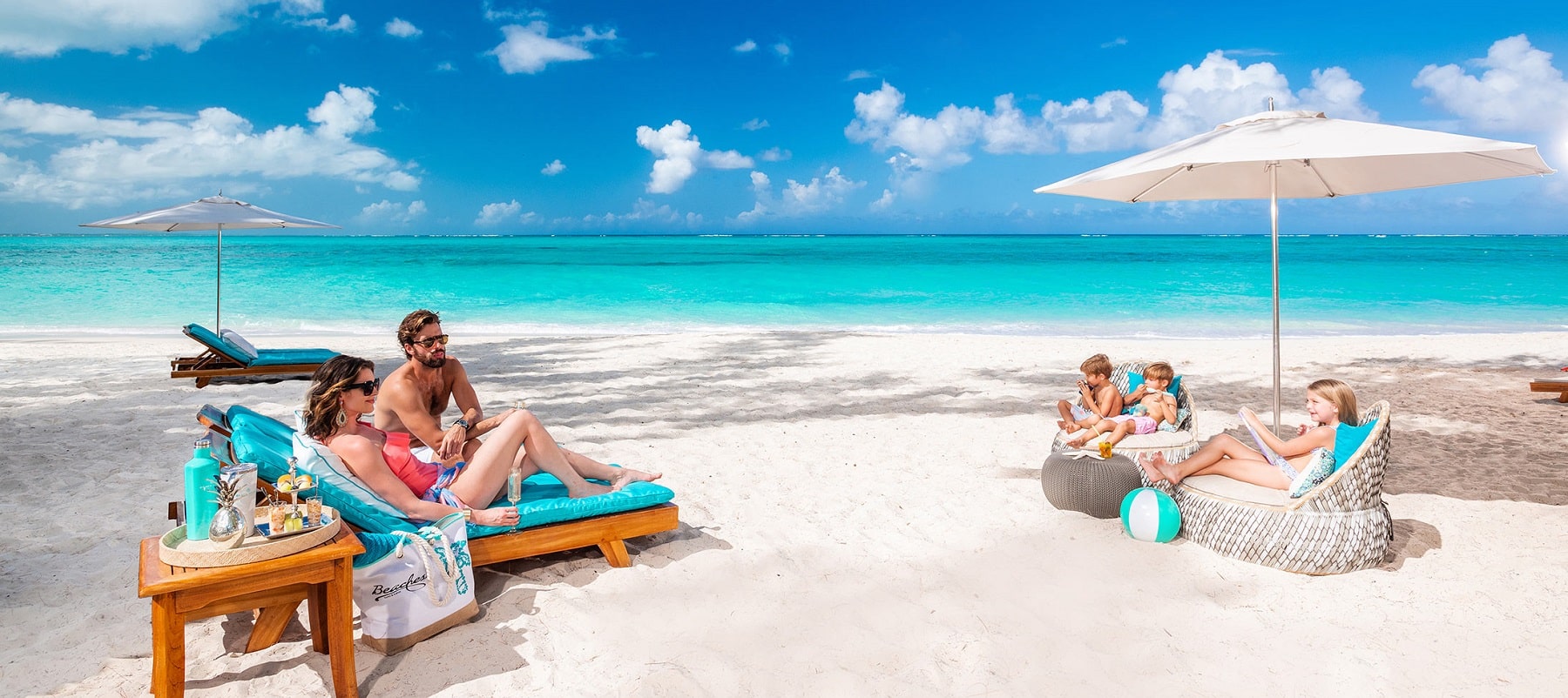 family relaxing on beach at beaches family resorts in the caribbean