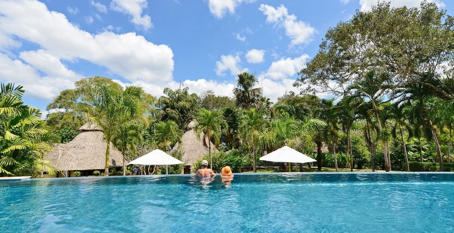 couple enjoying the cool water of the infinity pool overlooking the jungle of belize at chaa creek