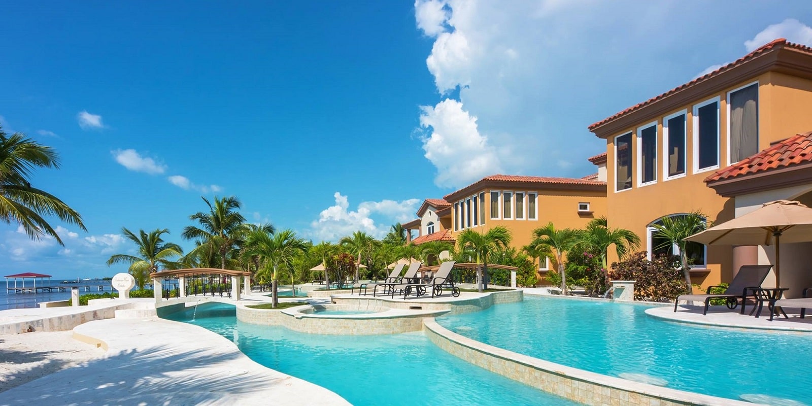 the beachfront pool with the two main buildings house the villas at belizean cove estates